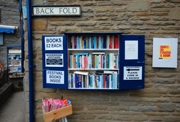Books sold from a hatch on a stone wall in Hay-on-Wye